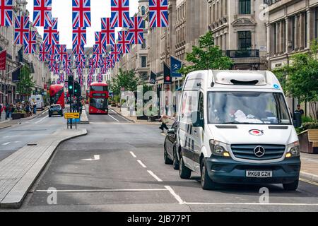 LONDON, UK - JUNE 03, 2022: Rows of Union flags hang above Regent Street to mark the Queen`s Platinum Jubilee celebrations. Stock Photo